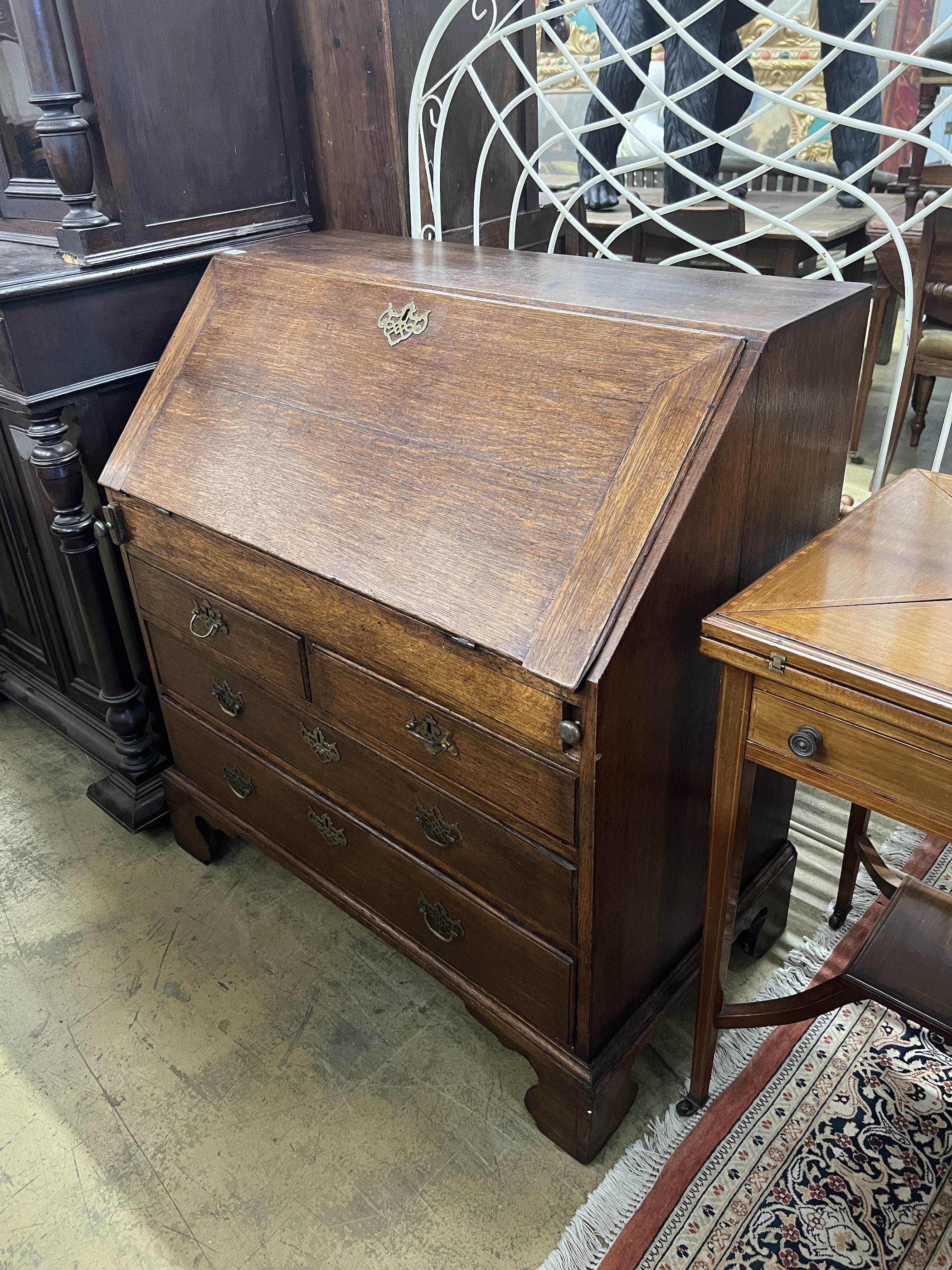 A George III oak bureau the interior with well, width 92cm, depth 53cm, height 101cm